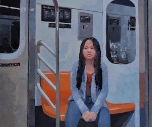 A young woman sits along on a New York subway. car