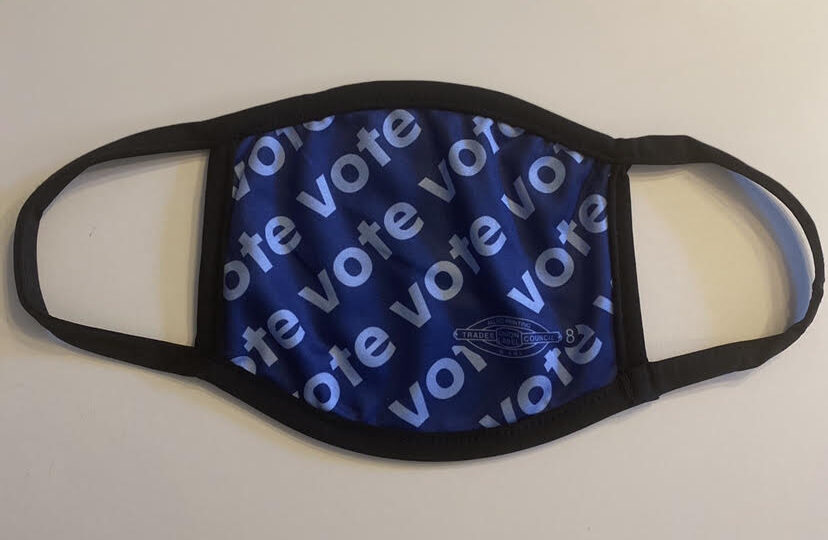 Image shows a COVID-19 mask with the words "vote" on it.