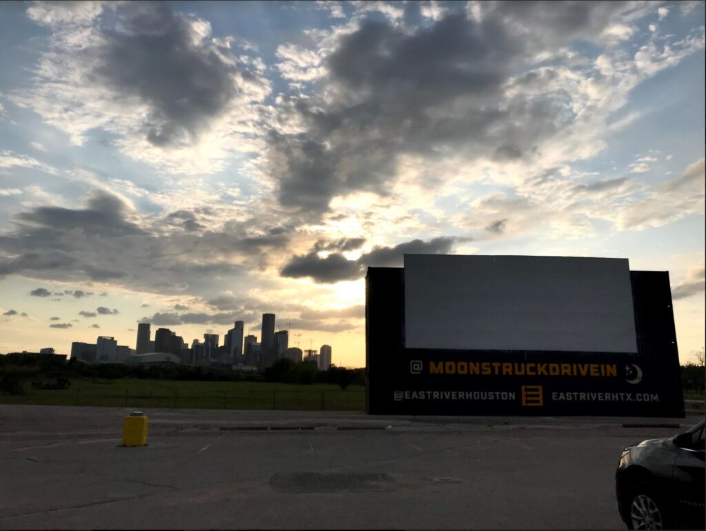 The sun begins to set over the Houston skyline before a movie begins rolling at Moonstruck Drive-In. [Credit: Corina Garcia]