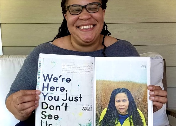 Woman with magazine that says "We're Here. You Just Don't See Us."