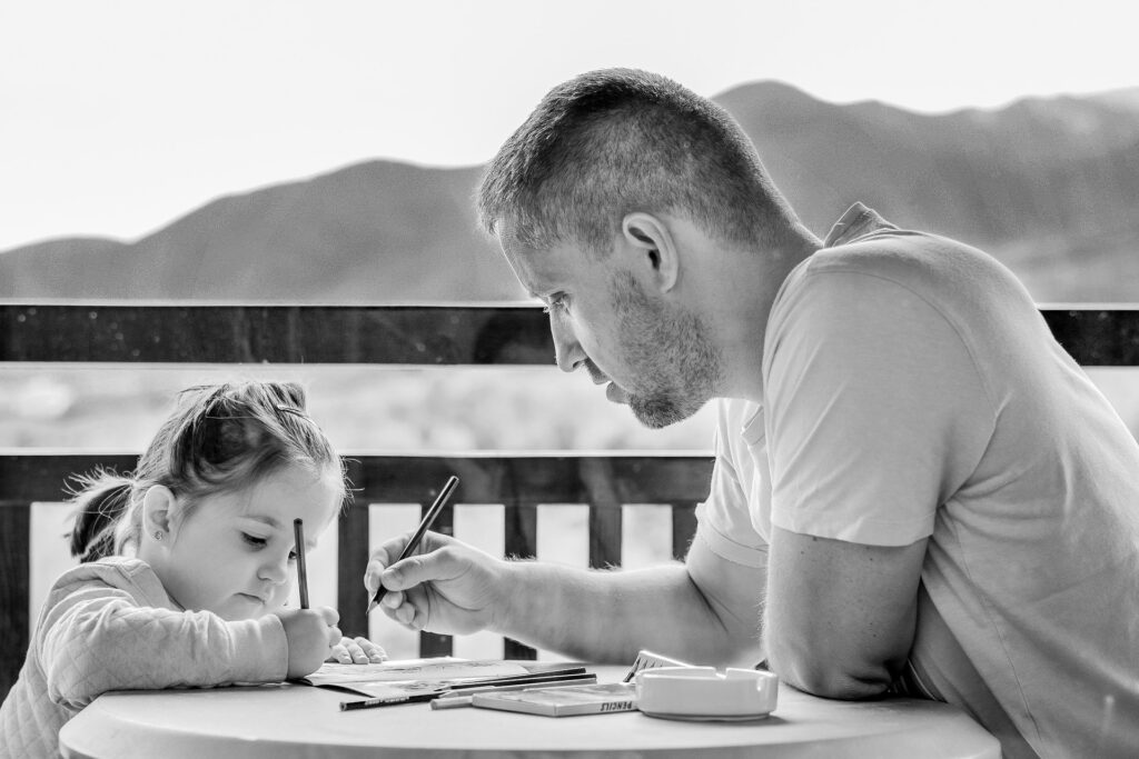 white dad and daughter coloring together