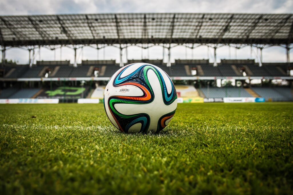 A soccer ball lies on a green grass field.