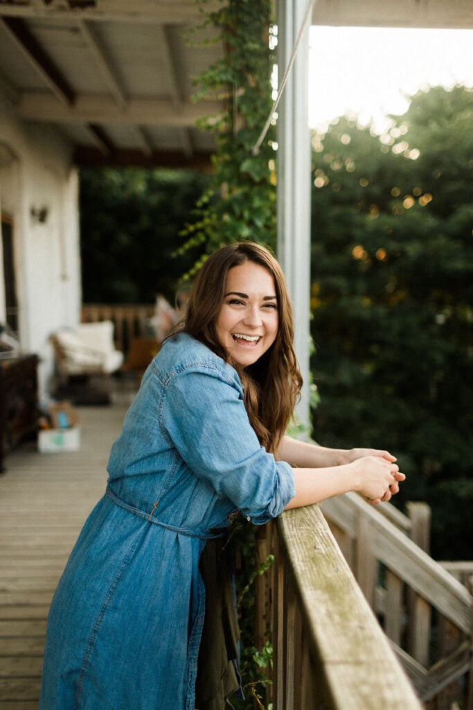 woman standing on a porch smiling