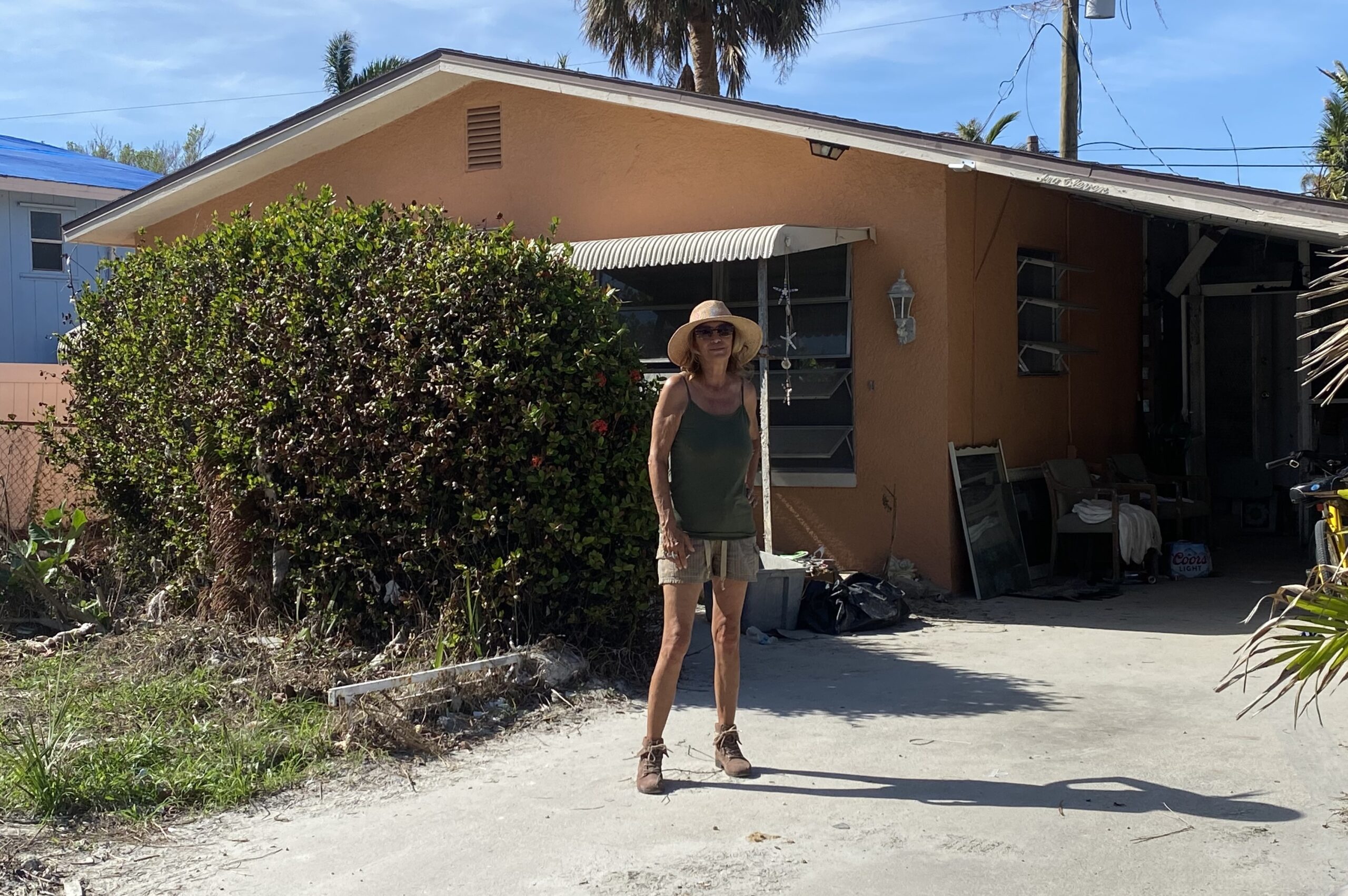 Resident Dawn Winston stands in front of her orange home where she and her husband weathered the storm. 