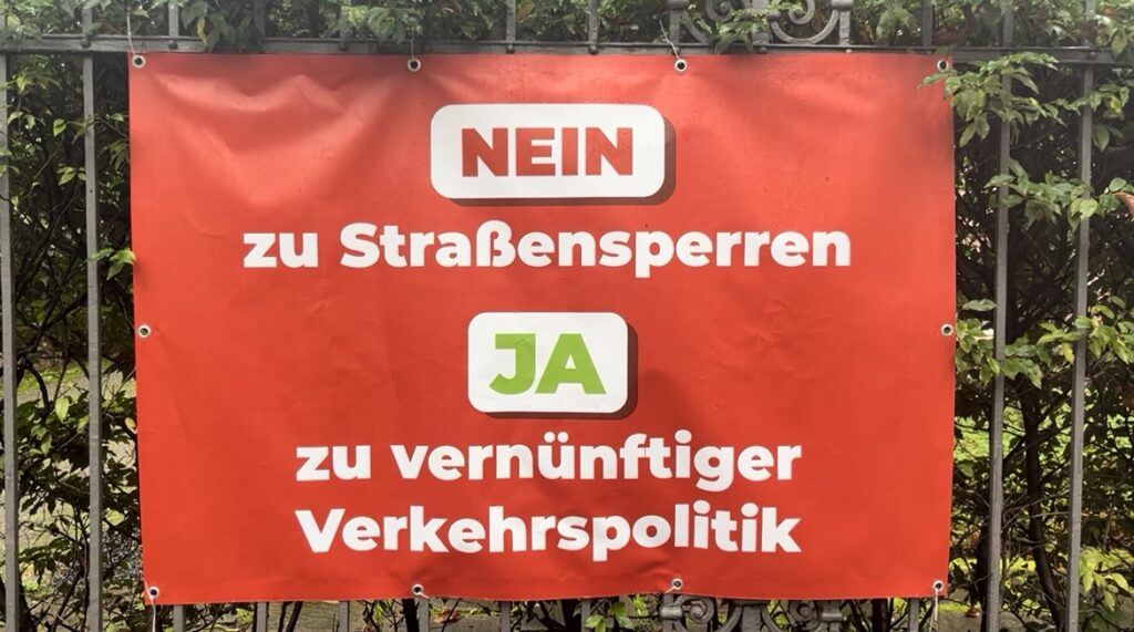 Picture of a red poster protesting traffic policies in German