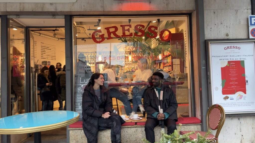Two people having coffee in front of the Gresso Cafe in Frankfurt am Main