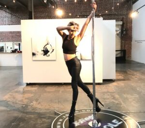 jaya king poses on pole in front of her artwork at Beatnik Studios art gallery in Sacramento.