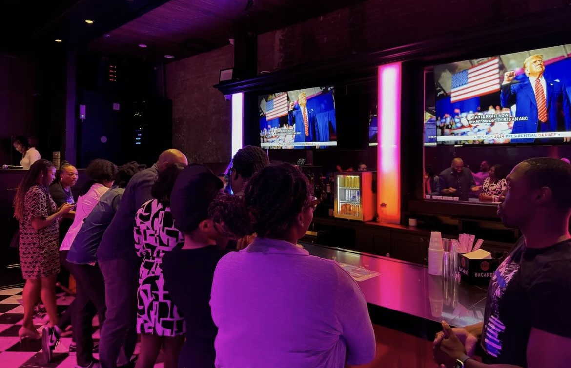 New Orleanians standing at bar watching the US presidential debate.