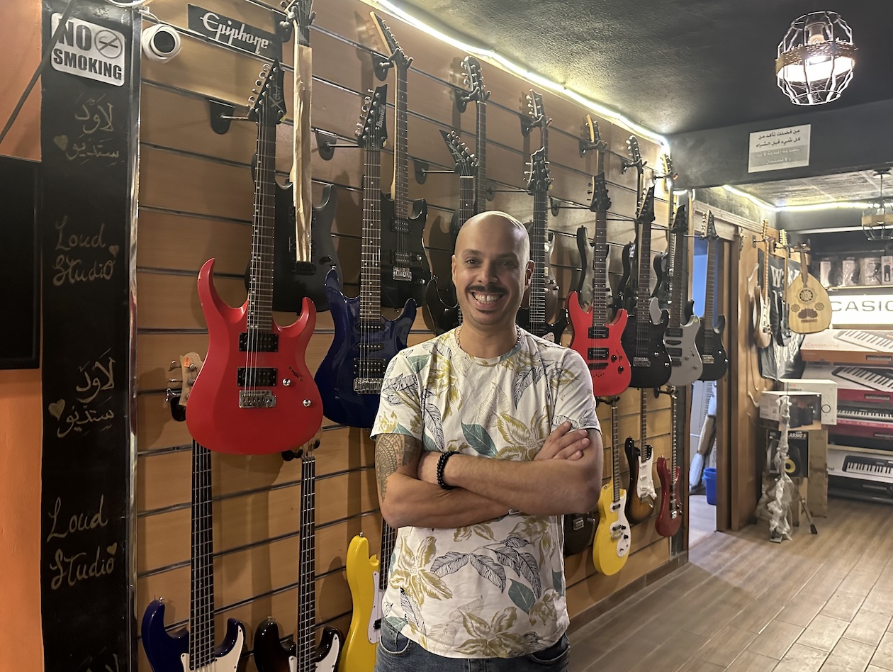 Hany Naga, store owner posing in front of his guitars