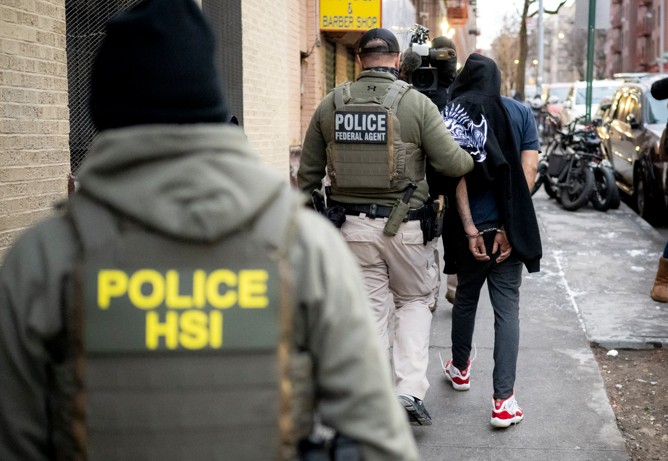 Homeland Security officers an individual during an immigration enforcement operation. [Credit HSI Media Library]