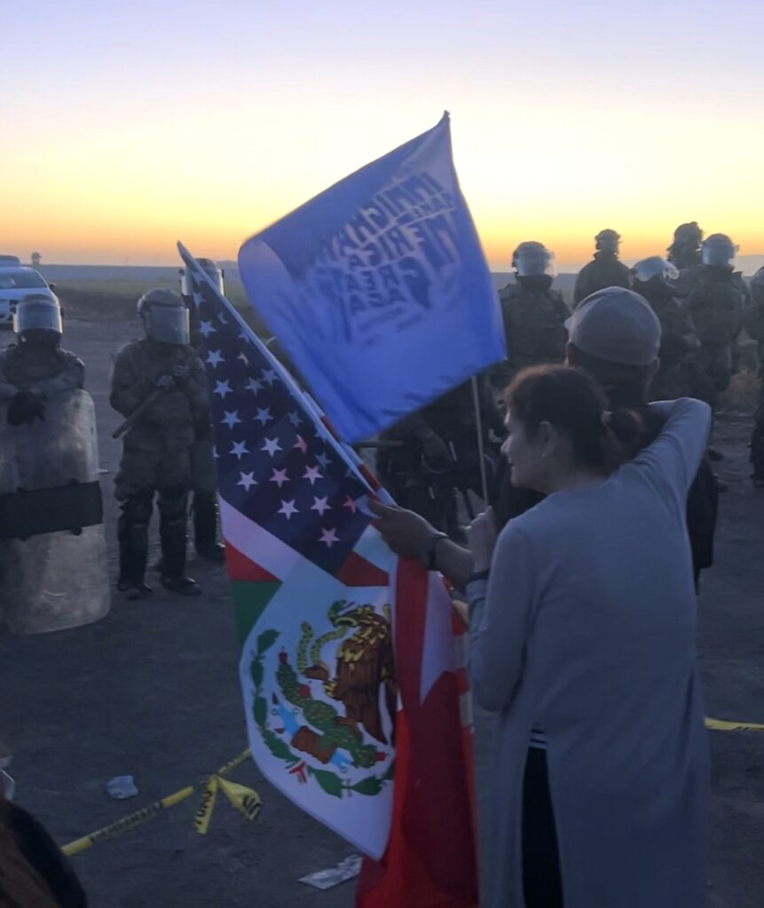 Protesters stand in front of National Guard members.