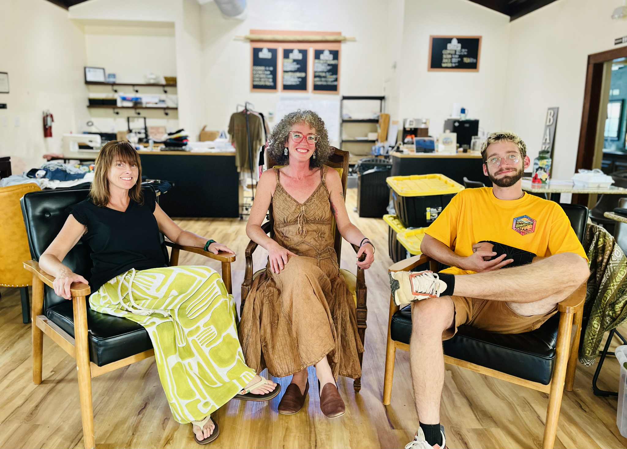 MAP Founder Kristin Watson sits inside the Tilted Map with Committee Lead for Workshops and Education Hillary Kline on her right and Volunteer and Case Manager David Moses on her left.