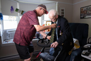 Burdett Sisler, 110, adjusts his tie with the help of his son, Norman, inside his Fort Erie, Ontario, home.