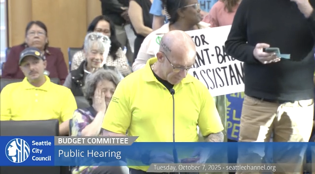 Man speaks into microphone at council meeting