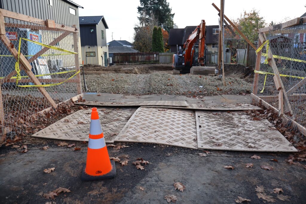 Photo of orange traffic cone in front of construction site