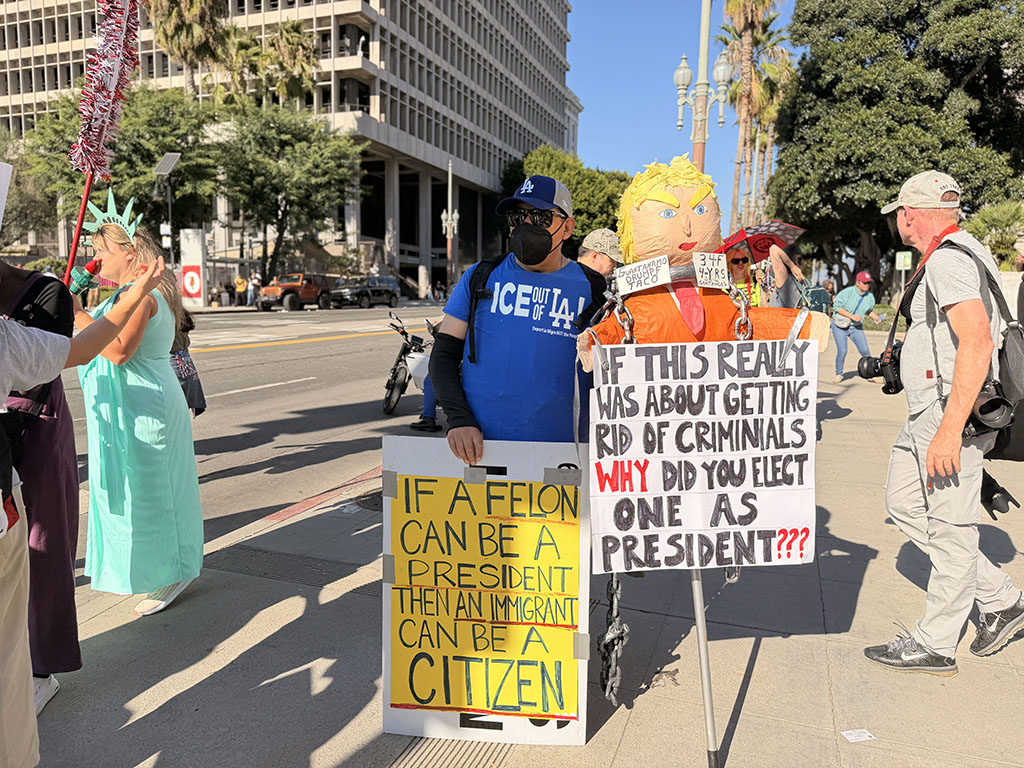 Protesters hold signs at a No Kings rally