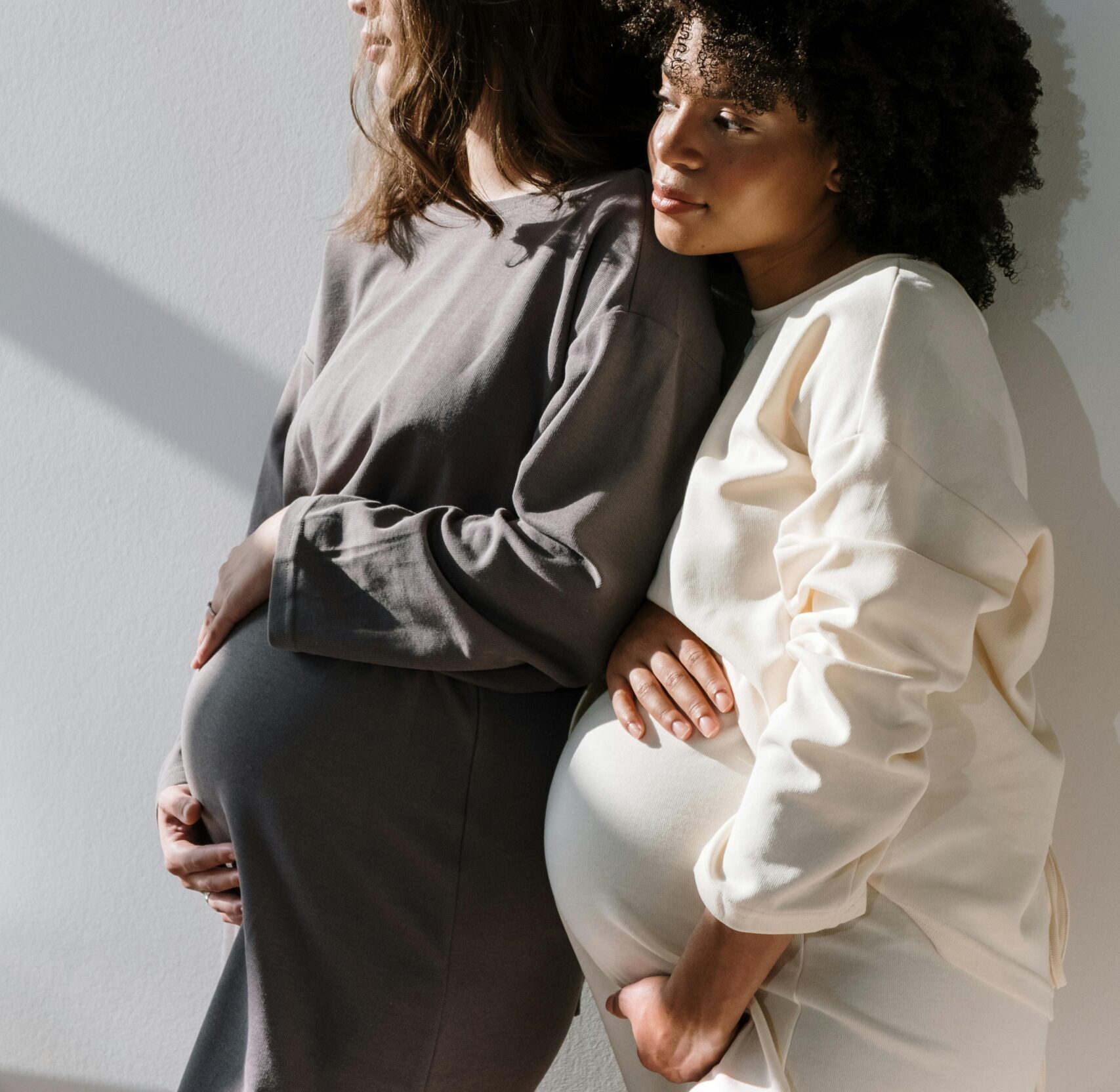 Woman in White Long Sleeve Shirt Hugging Woman in Black Long Sleeve Shirt