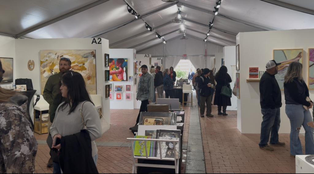 Visitors walking inside an art booth at Main Street Arts Festival
