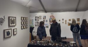 Sculpture artist Sam Sheath discussing artwork with a visitor 