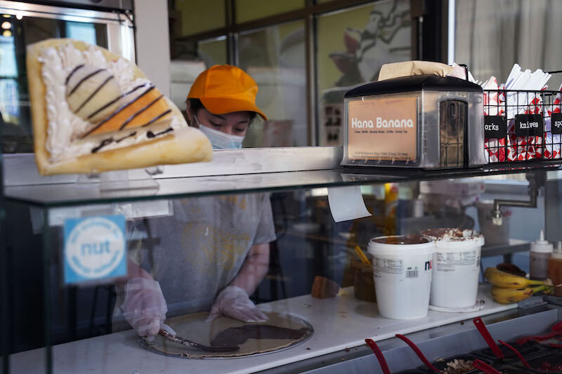 Abigail Vega spreads Nutella chocolate spread on crepe at Hana Banana, a local dessert spot, in El Paso, Texas, March 10, 2022.