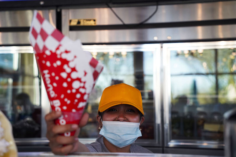A Hana Banana employee hands crepe dessert to customer in El Paso, Texas, March 10, 2022.