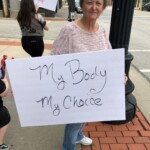 One woman holds a sign that says "My body my choice"